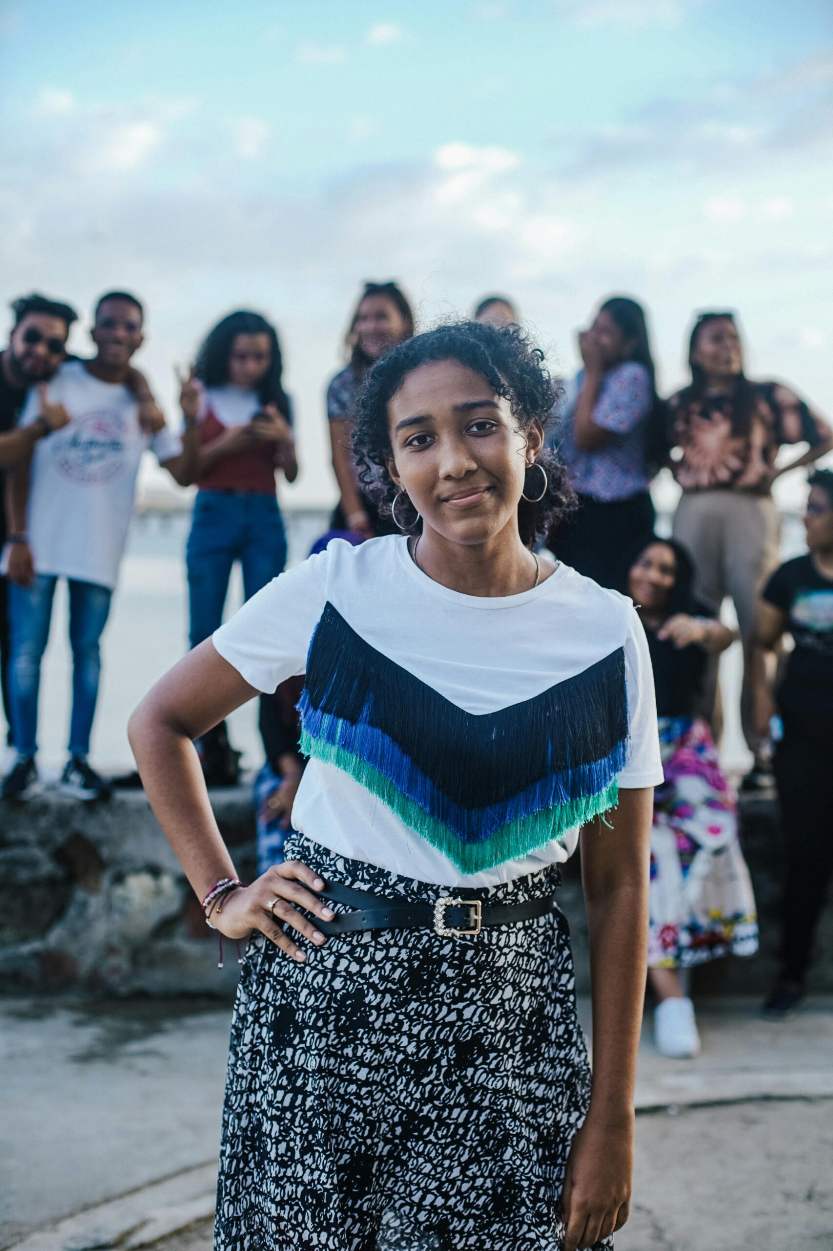 A diverse group of friends posing for a photo by the waterfront, showcasing friendship and joy.